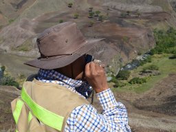 geologist amarante looking at an outcrop sample in the field